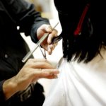 美容院で髪を切る女性