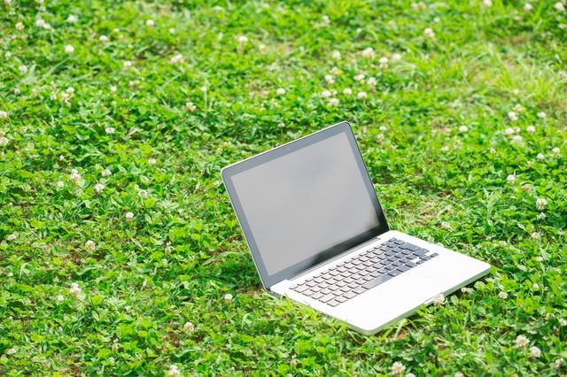 芝生上のノートパソコン