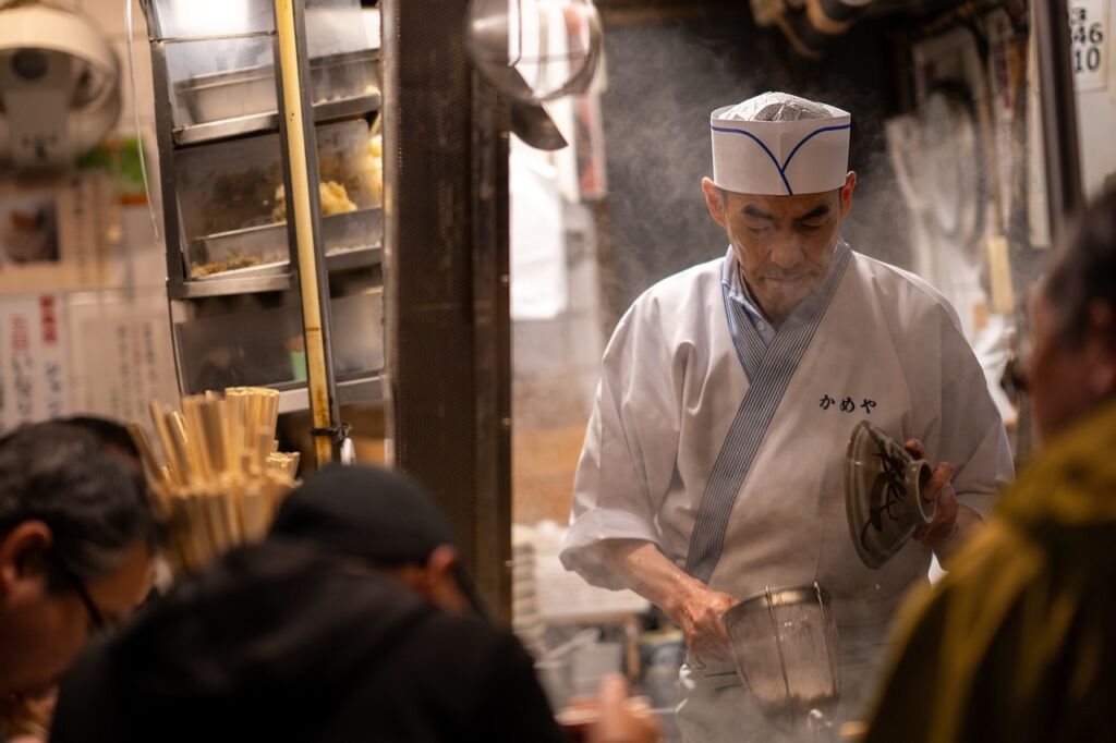 ラーメン屋で湯切りする大将