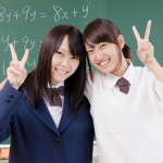 黒板の前でピースサインする2人の女子高校生